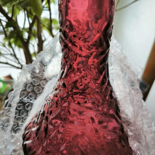 Schöne rote Glasvase mit Muster, ideal für Dekorationen.