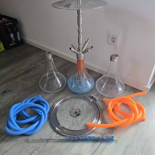 Shisha mit Glaskolben, Schläuchen und Zubehör auf Boden.
