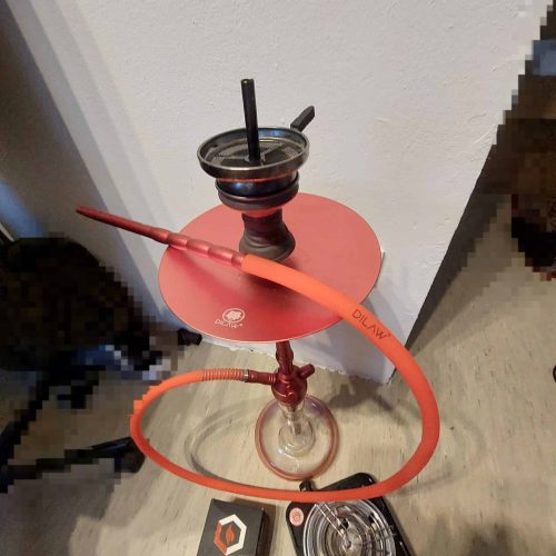 Shisha mit Wasserpfeife, Schlauch und Zubehör im Raum.