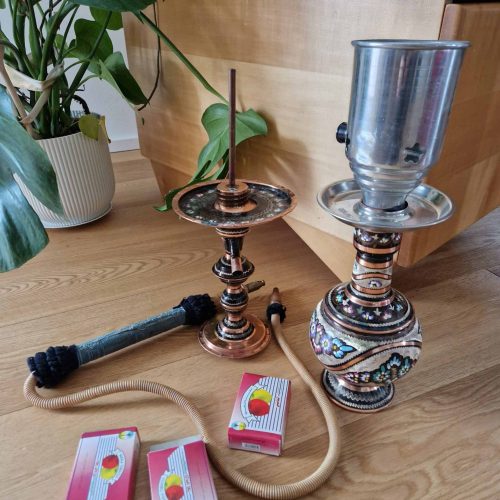 Wasserpfeife mit Kerzenhalter und Zubehör auf Holz.