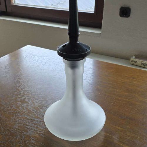 Shisha-Kopf auf Holzoberfläche vor Fenster.