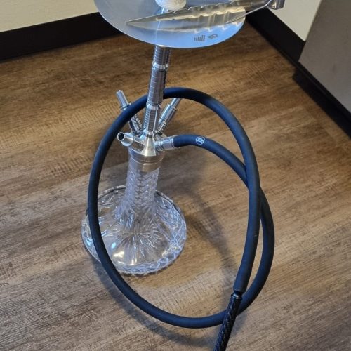 Shisha mit Rauchsäule und Schlauch in einem Raum.