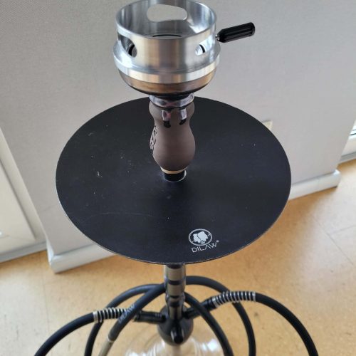 Dampfer mit Glasbowl und Kopf, geeignet für Shisha, auf einem schwarzen Tisch.