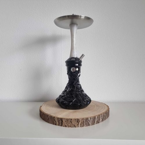 Shisha mit schwarzem Kopf und Metallaufsatz, auf Holzscheibe präsentiert.