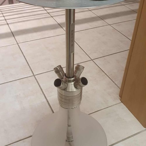 Rauchsäule mit Shisha-Glas und Aschenbecher auf Tisch.