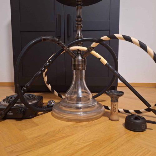 Shisha mit Glasbowl, Schläuchen und Kohlezange.