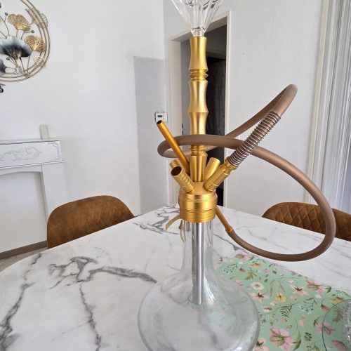 Shisha-Kopf mit Glasbowl, Schlauch und Düse auf Tisch.
