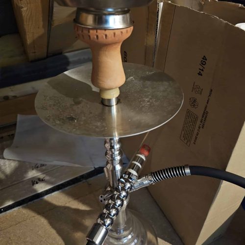 Shisha mit Glasbowl, Metallständer und Schlauch, ideal für Raucherlebnisse.