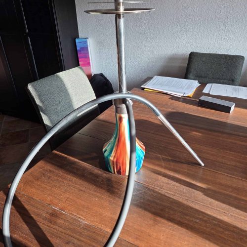 Shisha-Raucherset mit Silikonschlauch und Metallkopf auf Tisch.