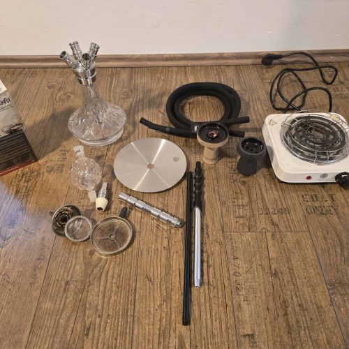 Verschiedene Shisha-Teile und Heizgerät auf Holzboden.