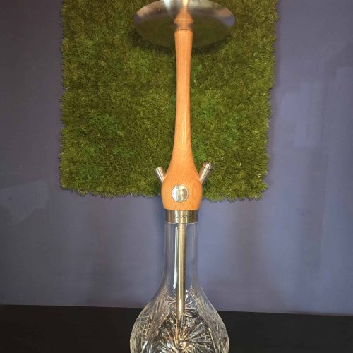 Rauchsäule mit Glasbase, Holzstück und Metallaufsatz.