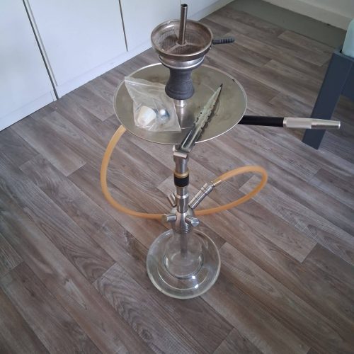 Moderne Shisha mit Glasbehälter und Schlauch, bereit zum Rauchen.