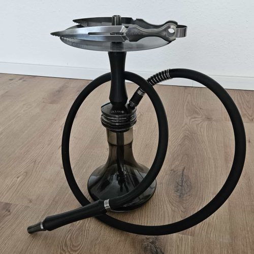 Shisha mit schwarzer Glasbowl und flexiblem Schlauch auf Holzboden.