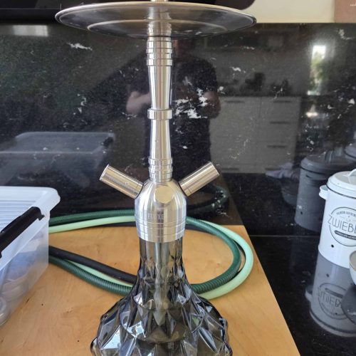 Silberne Shisha mit dekorativer Glasbowl auf Holztablett.