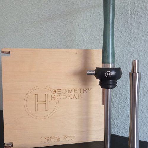 Shisha-Set mit Glasbowl, Metallrohr und Zubehör auf Tisch.