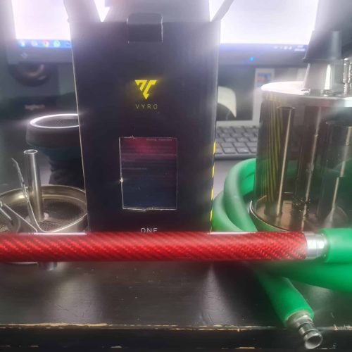 Shisha-Zubehör mit Glasbowl, Schlauch und Heizgerät auf Tisch.