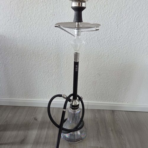 Shisha mit Glasbowl, Schlauch und Kopf, auf Boden stehend.