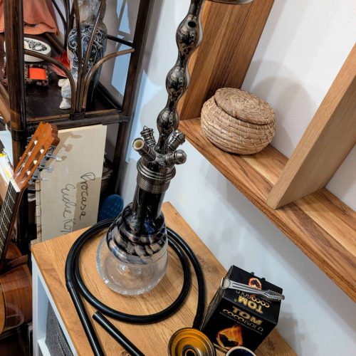 Rauch-Hookah mit Zubehör, Kohle und Schläuchen auf Holztablett.