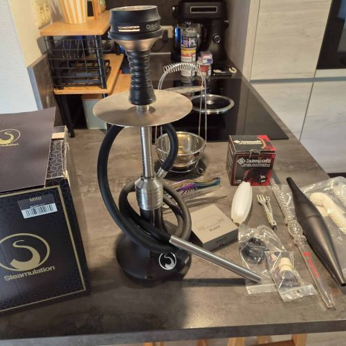 Shisha mit Silikonschlauch und Düse, komplett mit Zubehör, auf dunklem Tisch.