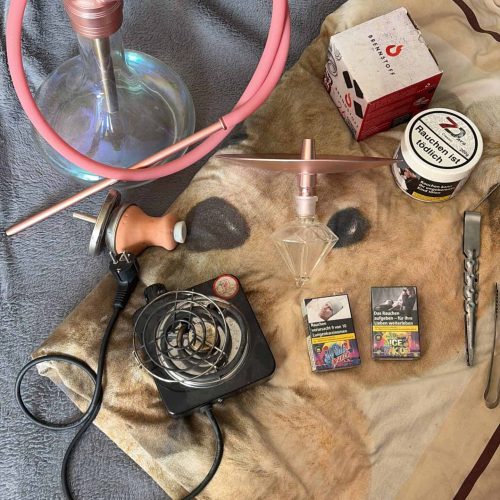 Verschiedene Shisha-Teile und Zubehör auf Tisch.