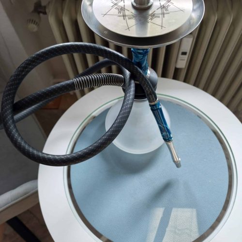 Shisha-Head mit Metalplatte und Schlauch auf Tisch.