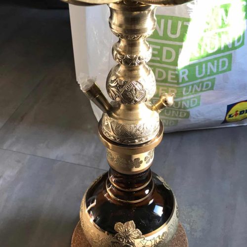 Dekorative Shisha mit goldenen Elementen und Blütenmuster, ideal für gemütliche Abende.