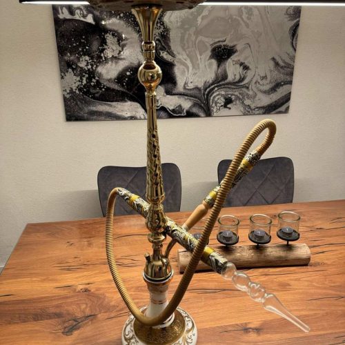 Shisha mit goldener Dekoration auf Holztablett, Kerzen und moderner Wandkunst im Hintergrund.