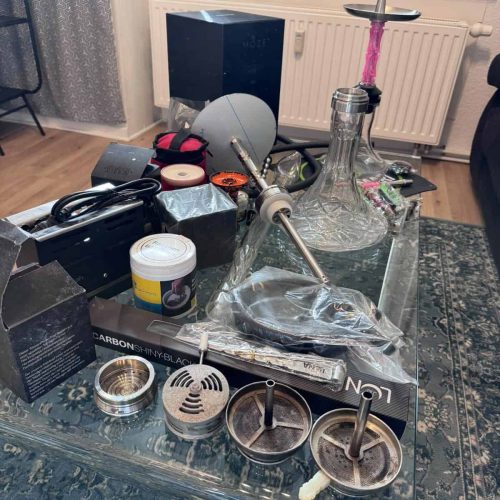 Verschiedene Shisha-Teile und Zubehör auf einem Tisch.