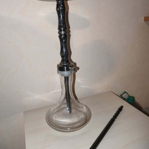 Hookah mit Glasbowl und Metallaufsatz auf Tisch.