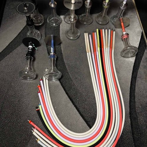 Verschiedene Glasbowl und flexible Shisha-Schläuche in bunten Farben.