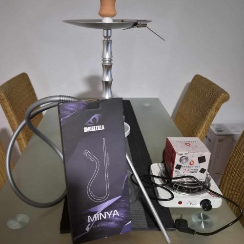 Shisha-Kopf mit Silikonschlauch und Zubehör auf Tisch.