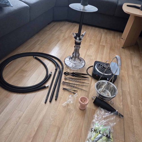 Verschiedene Shisha Teile und Zubehör auf Holzboden.