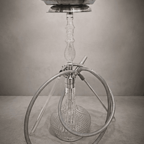 Shisha mit Glasbowl, Metallstange und Schlauch auf Boden.