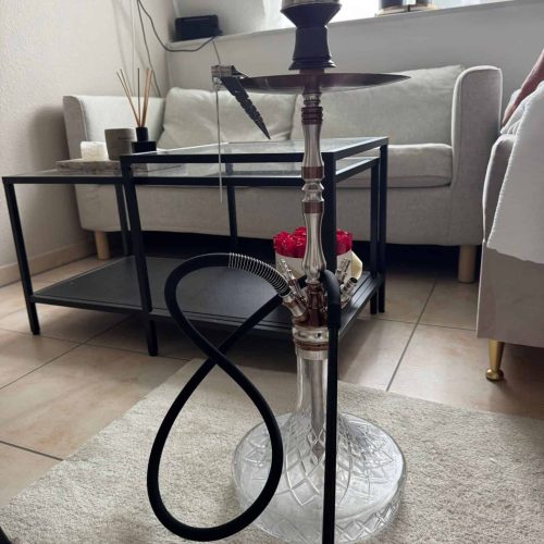 Rauchpfeife auf einem Glasständer in einem modernen Wohnzimmer.