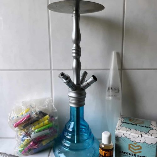 Rauchsäule mit Zubehör, Tabak und Reinigungsmittel auf Fliesen.