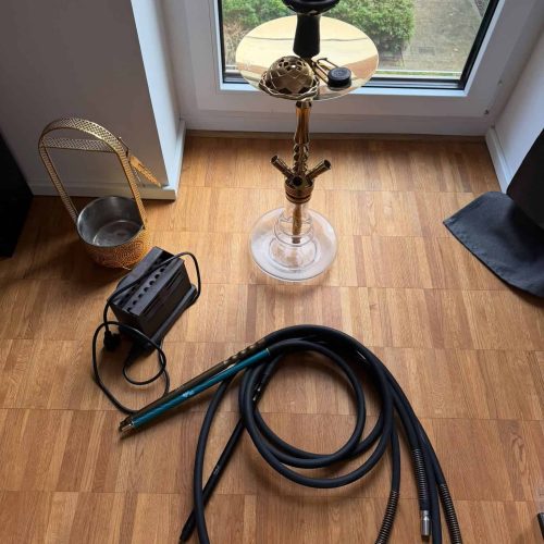 Shisha Bowl mit Schlauch und Zubehör vor Fenster.