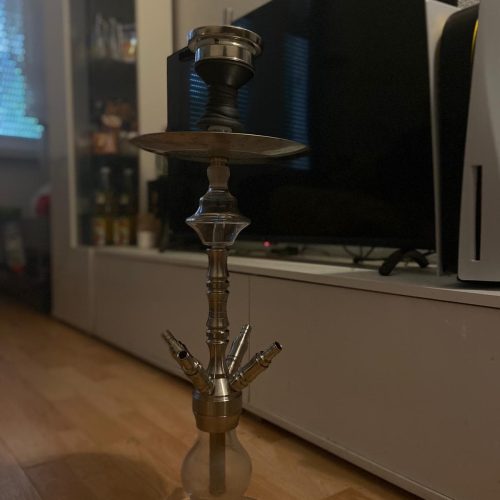 Rauchpfeife mit Glasbowl und Kopf, auf Holzboden in Wohnzimmer.