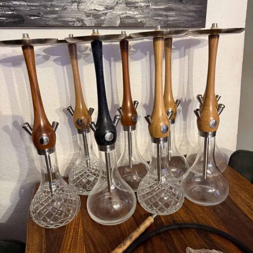 Verschiedene Shisha Glasbowl Modelle in Holz- und Schwarz-Designs.