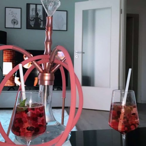 Shisha mit rosa Design und zwei Gläsern mit Getränken.