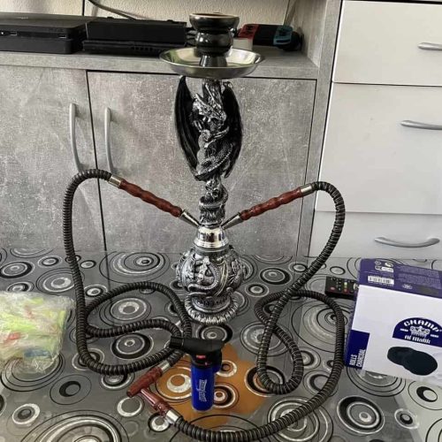 Raucherset mit Shisha, Schlauch und Kohlebox auf Küchentisch.