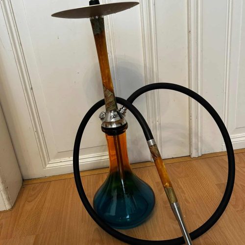 Shisha mit Glasgefäß, Schlauch und Tabak, bereit zum Rauchen.