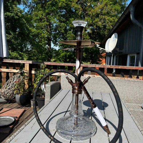 Shisha mit Glasbasis und Schlauch im Freien.
