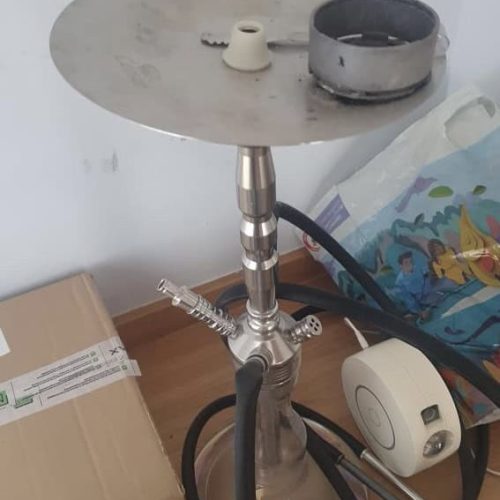 Shisha mit Schlauch und Kopf auf einem Tisch, bereit zum Rauchen.