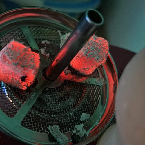 Shisha mit glühenden Kohlen und Wasserpfeife, Nahaufnahme.