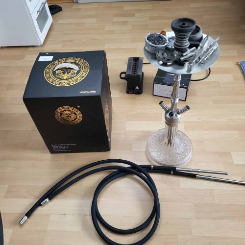 Komplettes Shisha-Set mit Kopf, Schlauch und Zubehör auf Holzboden.