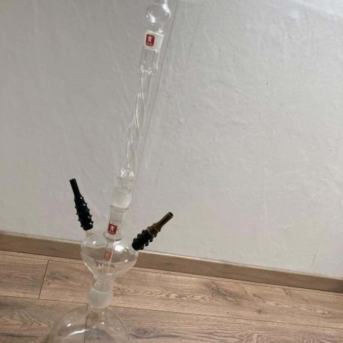 Glas-Shisha mit Glasbowl und zwei Schläuchen, auf Holzboden.