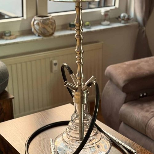 Rauchende Wasserpfeife auf einem Tisch in einem Wohnzimmer.