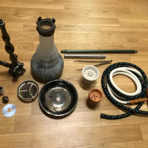 Verschiedene Shisha Teile, inklusive Glasbowl, Schlauch und Dichtungen.