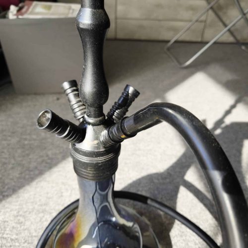 Schwarze Shisha mit Metall- und Glasbowl, auf Terrasse.