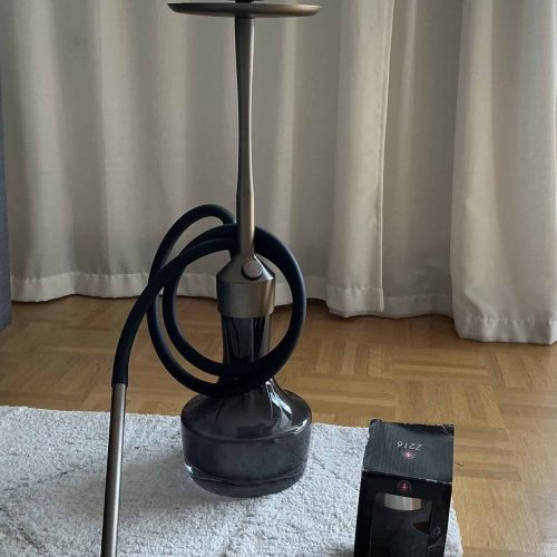 Shisha mit Glasbowl, Schlauch und Zubehör im Raum.